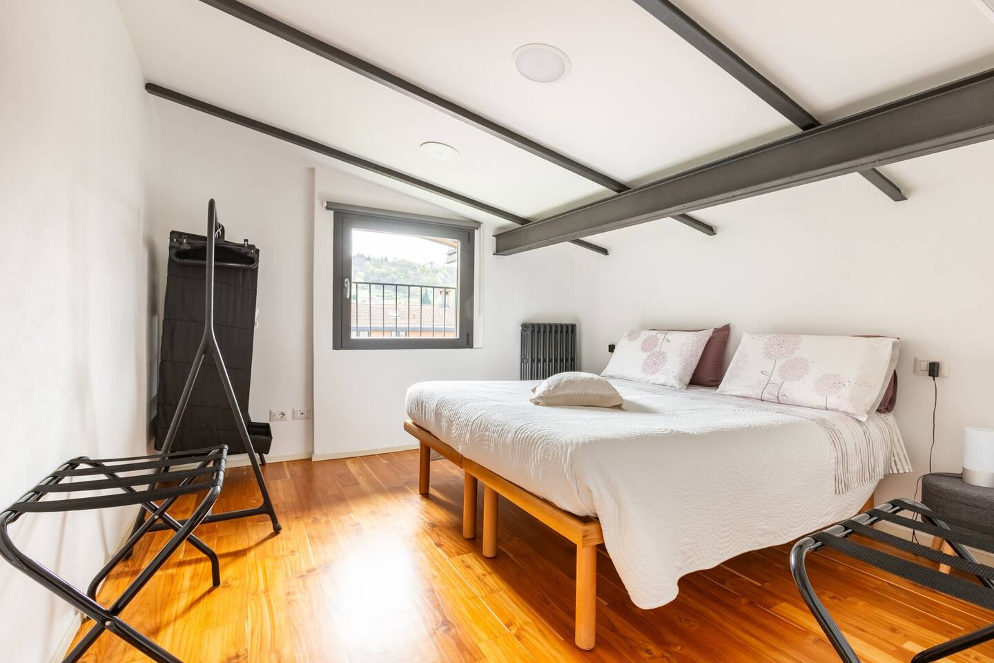 Camera da letto matrimoniale de La Casa degli Ulivi con pavimento in parquet, travi a vista e finestra panoramica - Design moderno e accogliente con biancheria di qualità
